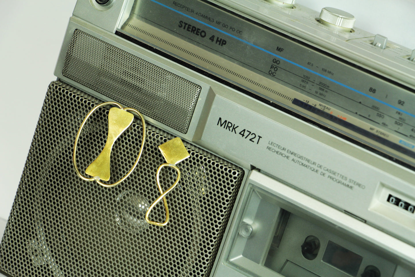 Boucles d'oreilles Adna sur un poste stéréo rétro.