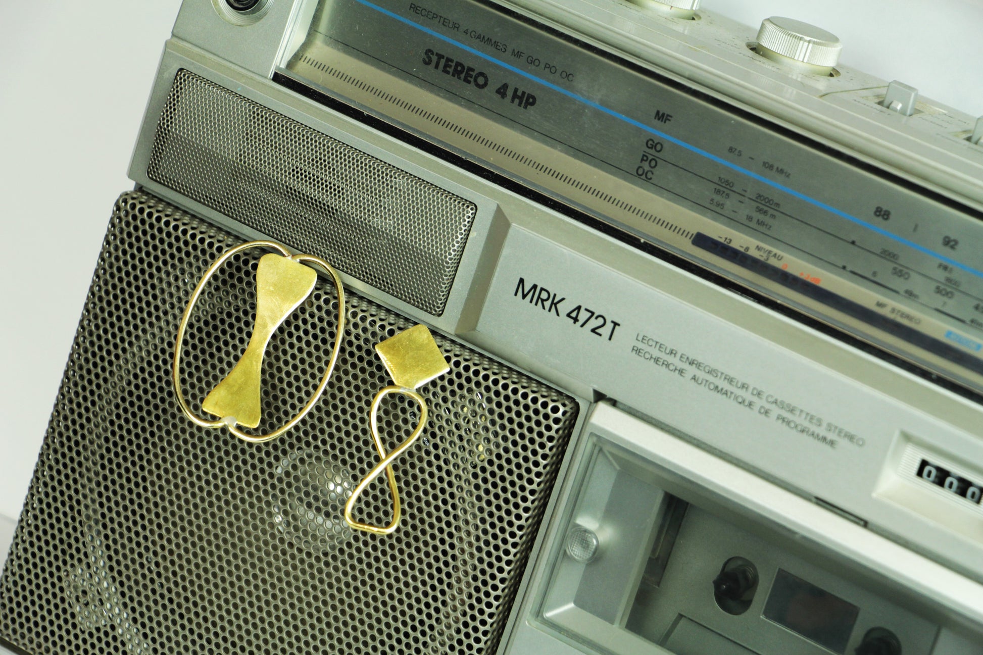 Boucles d'oreilles Adna sur un poste stéréo rétro.