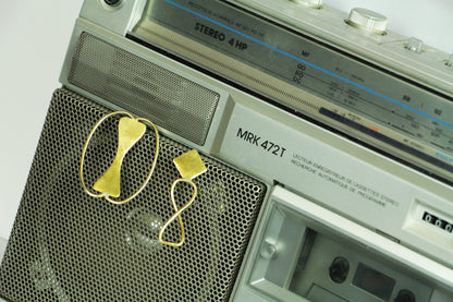 Boucles d'oreilles Adna sur un poste stéréo rétro.