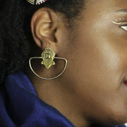 Femme peau noire portant les boucles d'oreilles Ifè